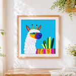 Finished colourful geometric alpaca with cacti cross stitch artwork displayed