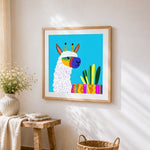 Colourful geometric alpaca with cacti cross stitch artwork displayed on wall as home decor