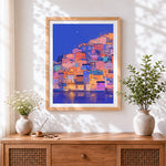 Finished colourful hillside village at night cross stitch artwork displayed