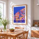 Colourful hillside village at night cross stitch artwork displayed on wall as home decor