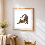 Colourful mandala cat stretching cross stitch artwork displayed on wall as home decor