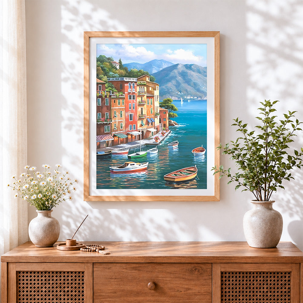 Finished colourful mediterranean coastal town cross stitch artwork displayed
