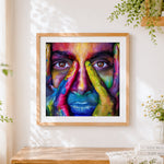 Finished colourful painted face close-up cross stitch artwork displayed