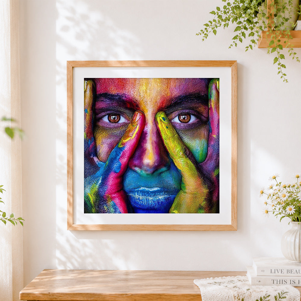 Finished colourful painted face close-up cross stitch artwork displayed
