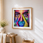Colourful painted face close-up cross stitch artwork displayed on wall as home decor