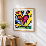 Colourful pop art cartoon hearts cross stitch artwork displayed on wall as home decor