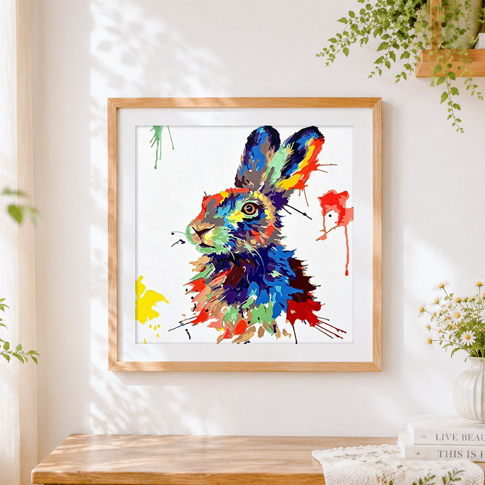 Finished colourful splatter hare cross stitch artwork displayed