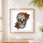 Finished colourful sugar skull with orange roses cross stitch artwork displayed