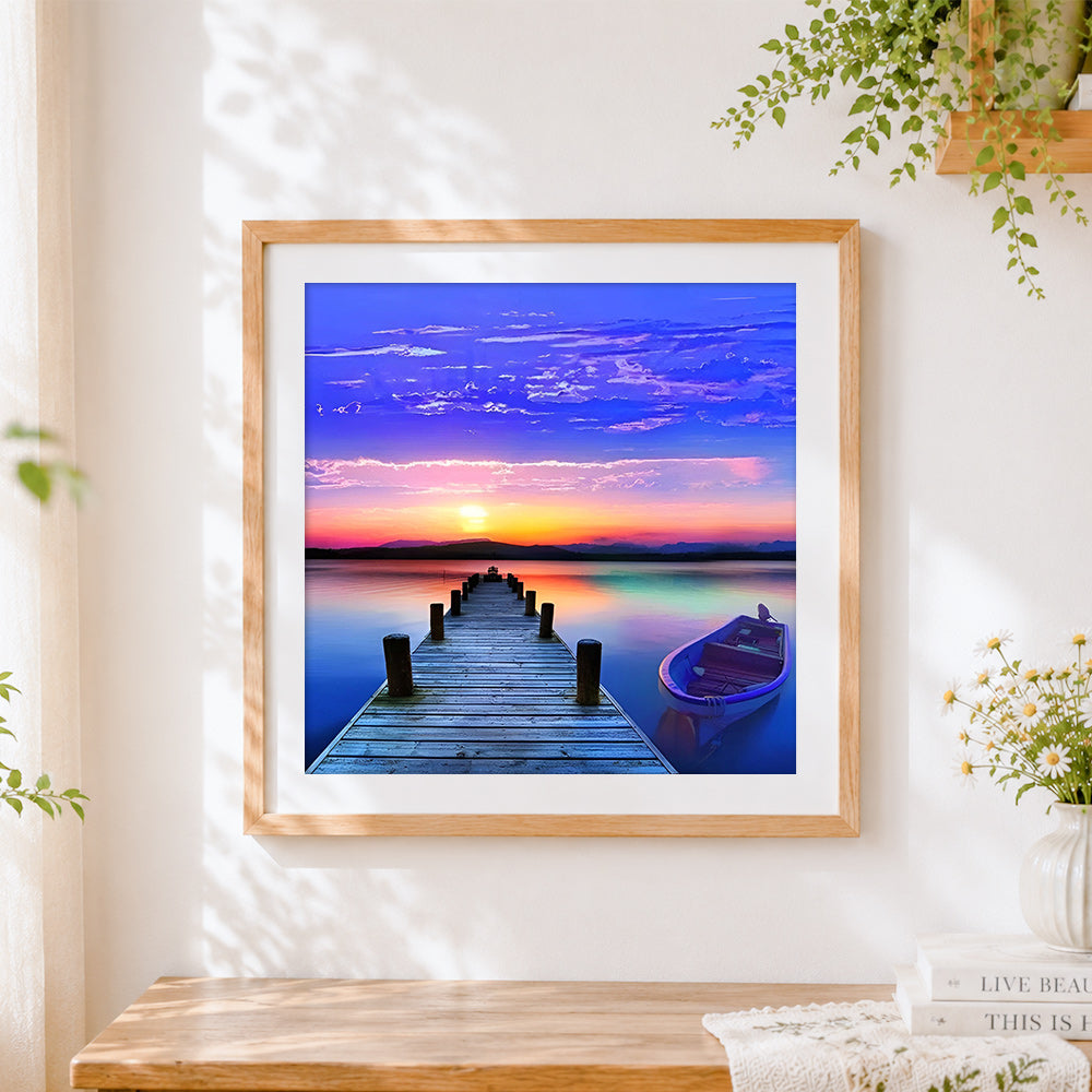 Finished colourful sunset pier with boat cross stitch artwork displayed