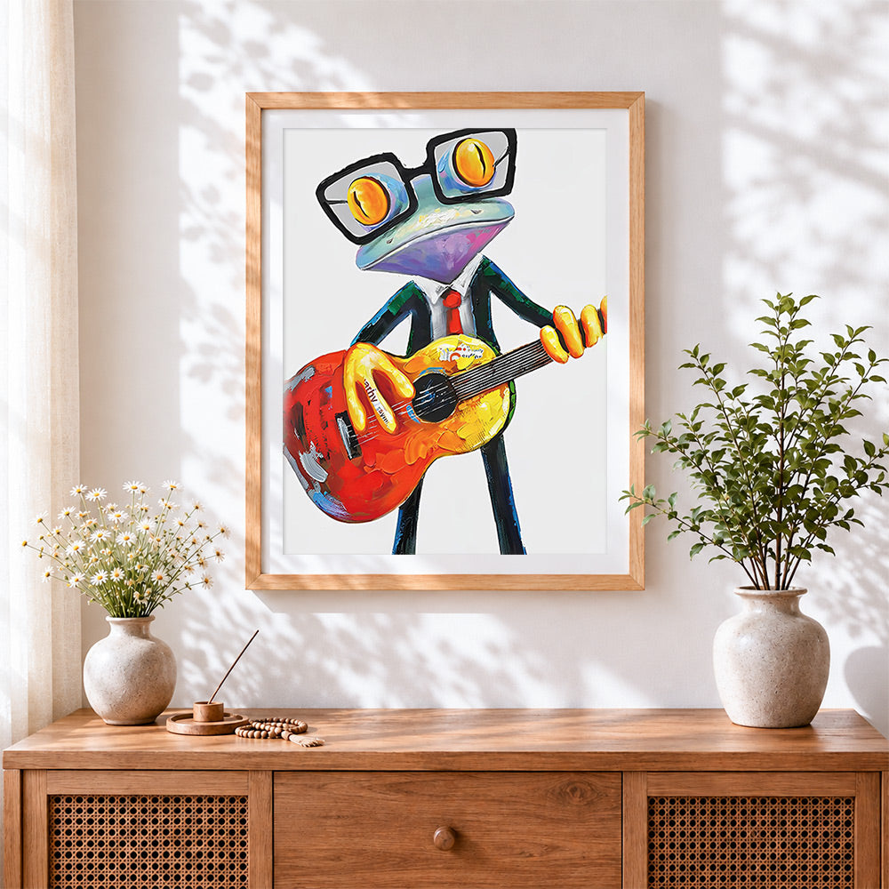 Finished cool frog playing guitar cross stitch artwork displayed