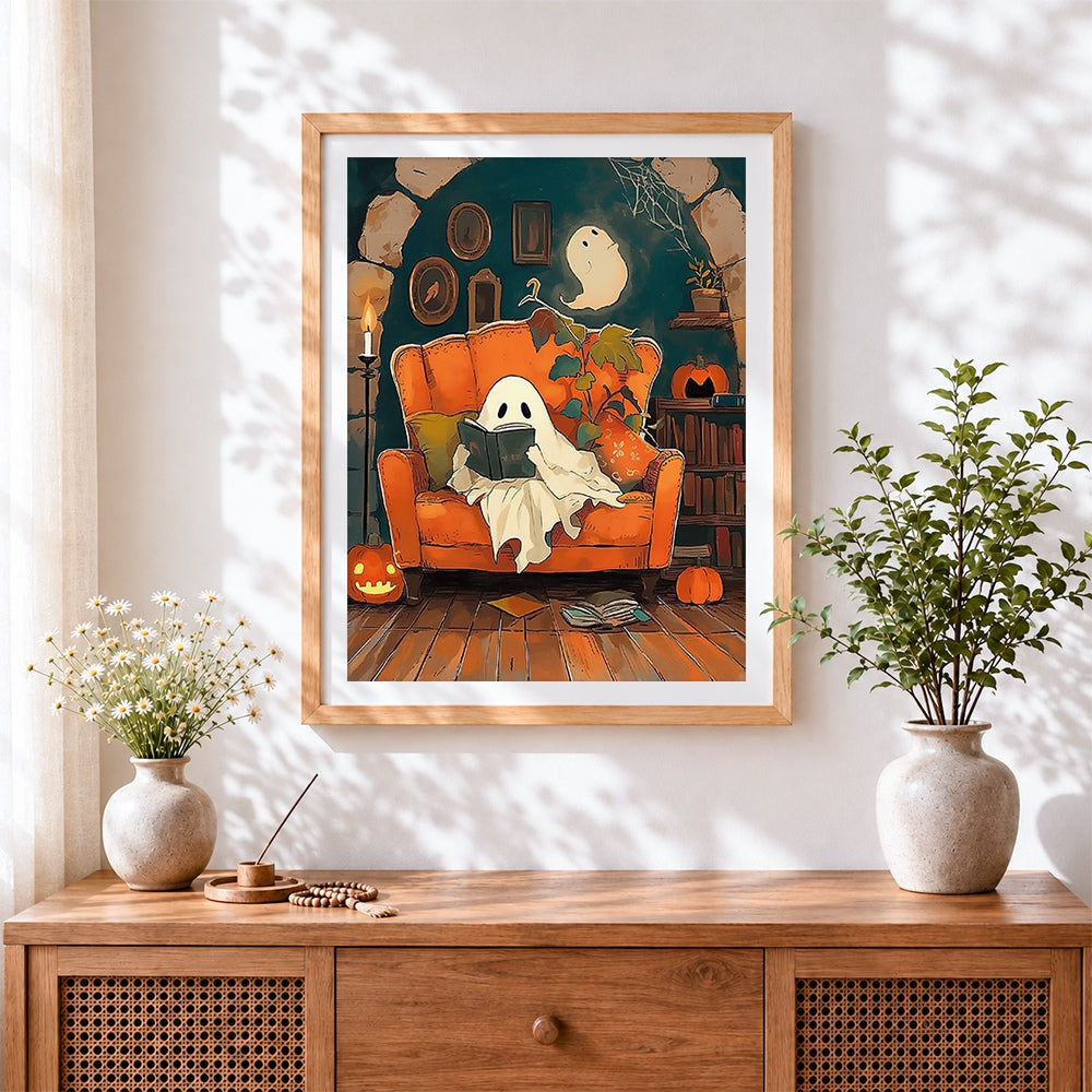 Finished cosy ghost reading in armchair cross stitch artwork displayed