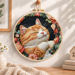 Cosy napping orange cat embroidery hoop wall art displayed as warm and cosy handmade home decor