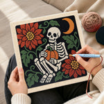 Creating handmade cosy skeleton holding pumpkin punch needle artwork