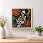 Finished cosy skeleton holding pumpkin artwork displayed on a wall