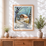 Finished cosy snowy cottage and christmas tree cross stitch artwork displayed