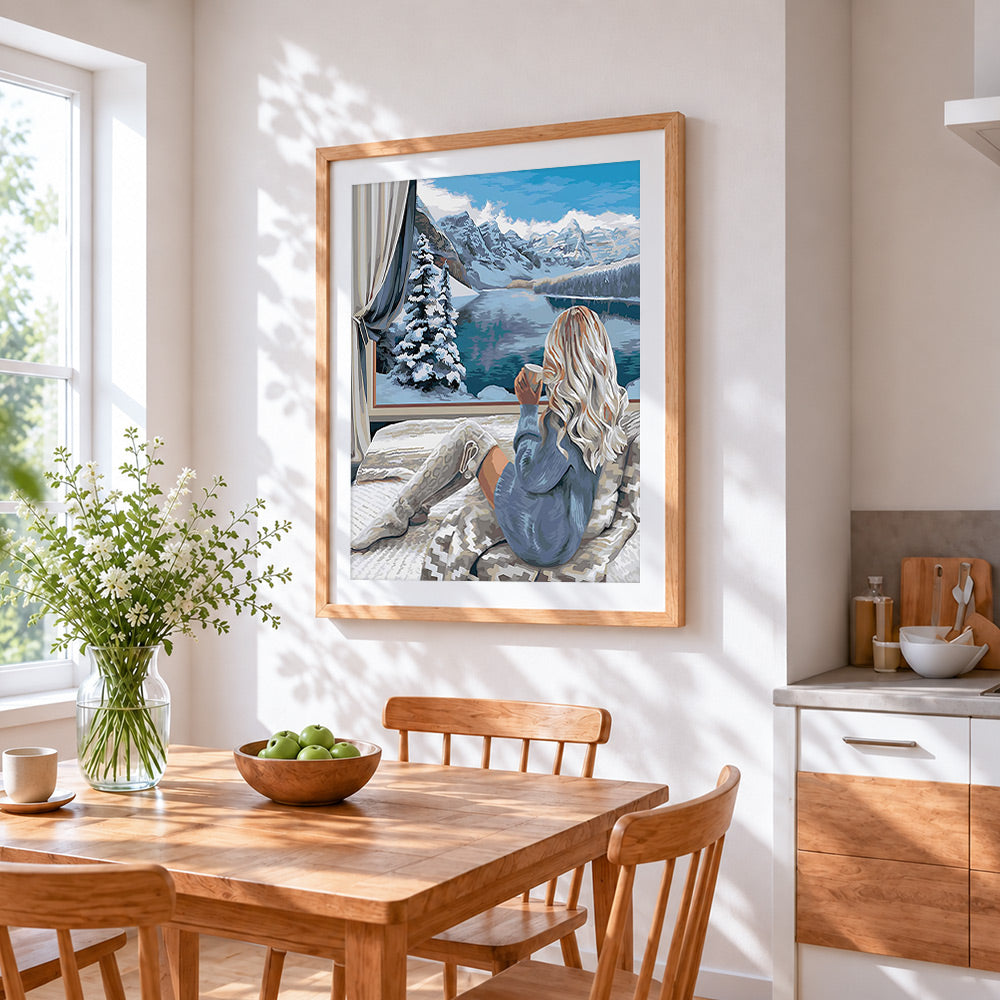 Cosy winter window mountain view cross stitch artwork displayed on wall as home decor