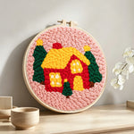Cozy christmas cabin punch needle artwork displayed on a table