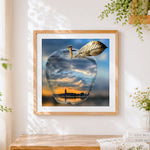 Finished crystal apple with city sunset reflection cross stitch artwork displayed