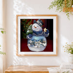 Finished crystal snowman snow globe cross stitch artwork displayed