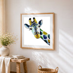 Curious giraffe cross stitch artwork displayed on wall as home decor