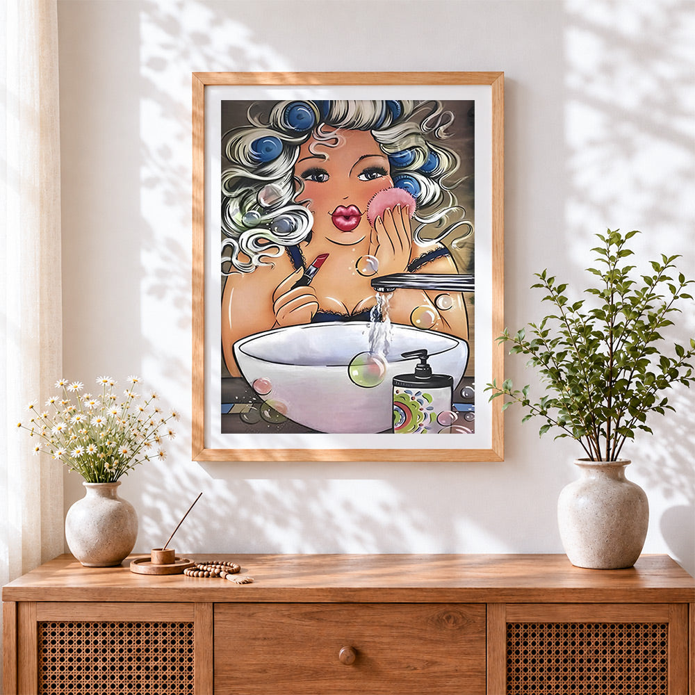 Finished curvy woman applying makeup cross stitch artwork displayed