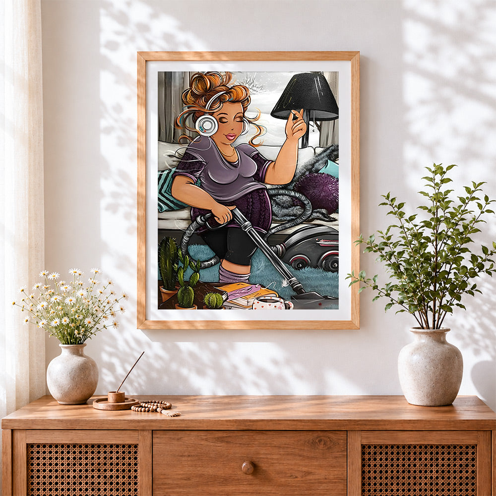 Finished curvy woman vacuuming with headphones cross stitch artwork displayed