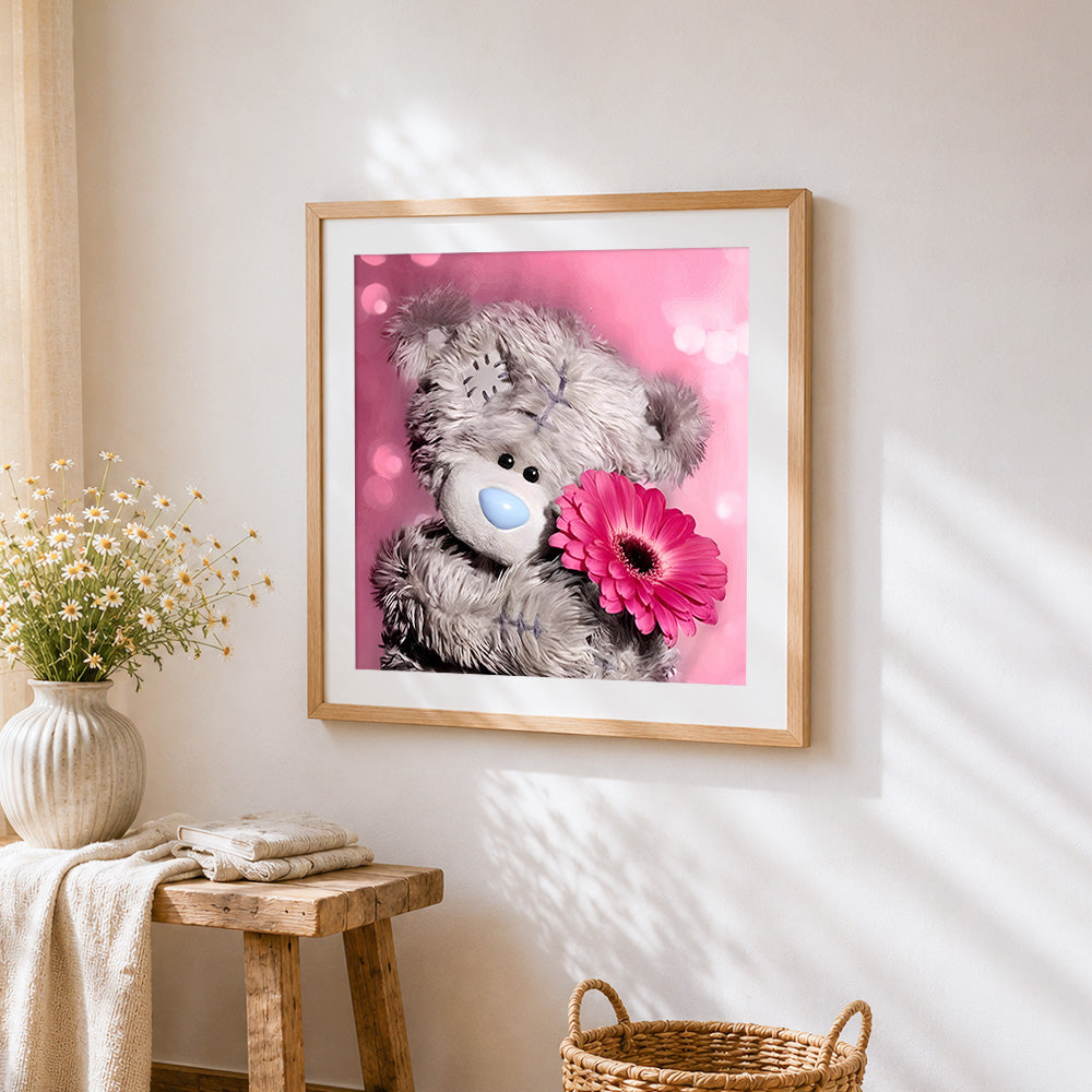 Cute bear with pink gerbera cross stitch artwork displayed on wall as home decor
