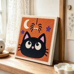 Cute black cat punch needle artwork displayed on a table
