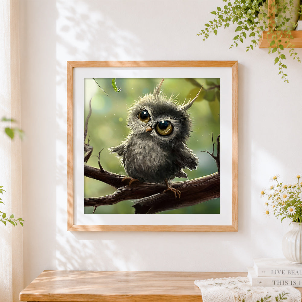 Finished cute fluffy owl chick with caterpillar cross stitch artwork displayed