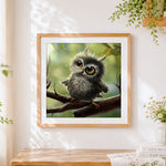 Finished cute fluffy owl chick with caterpillar cross stitch artwork displayed