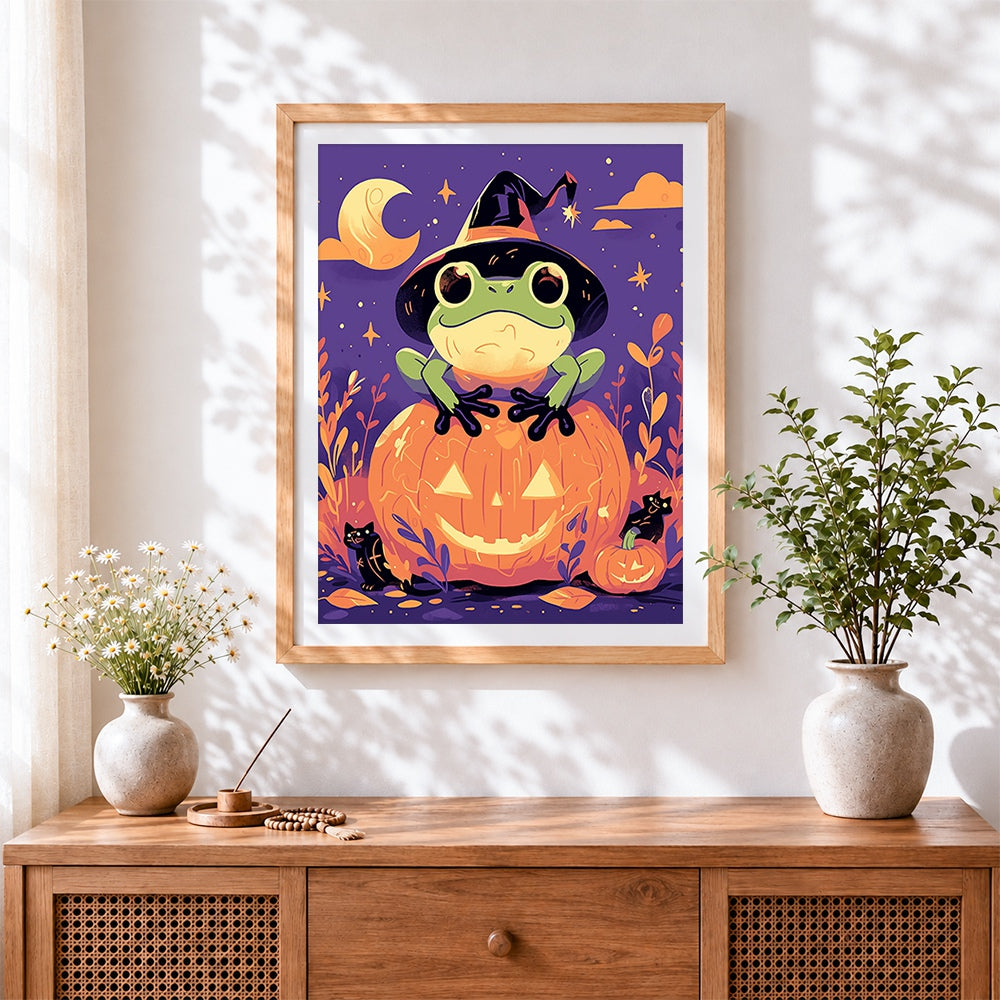 Finished cute frog on glowing pumpkin cross stitch artwork displayed