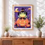 Finished cute frog on glowing pumpkin cross stitch artwork displayed
