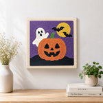 Finished cute ghost with jack‑o‑lantern artwork displayed on a wall