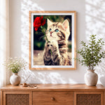 Finished cute kitten holding a red rose cross stitch artwork displayed
