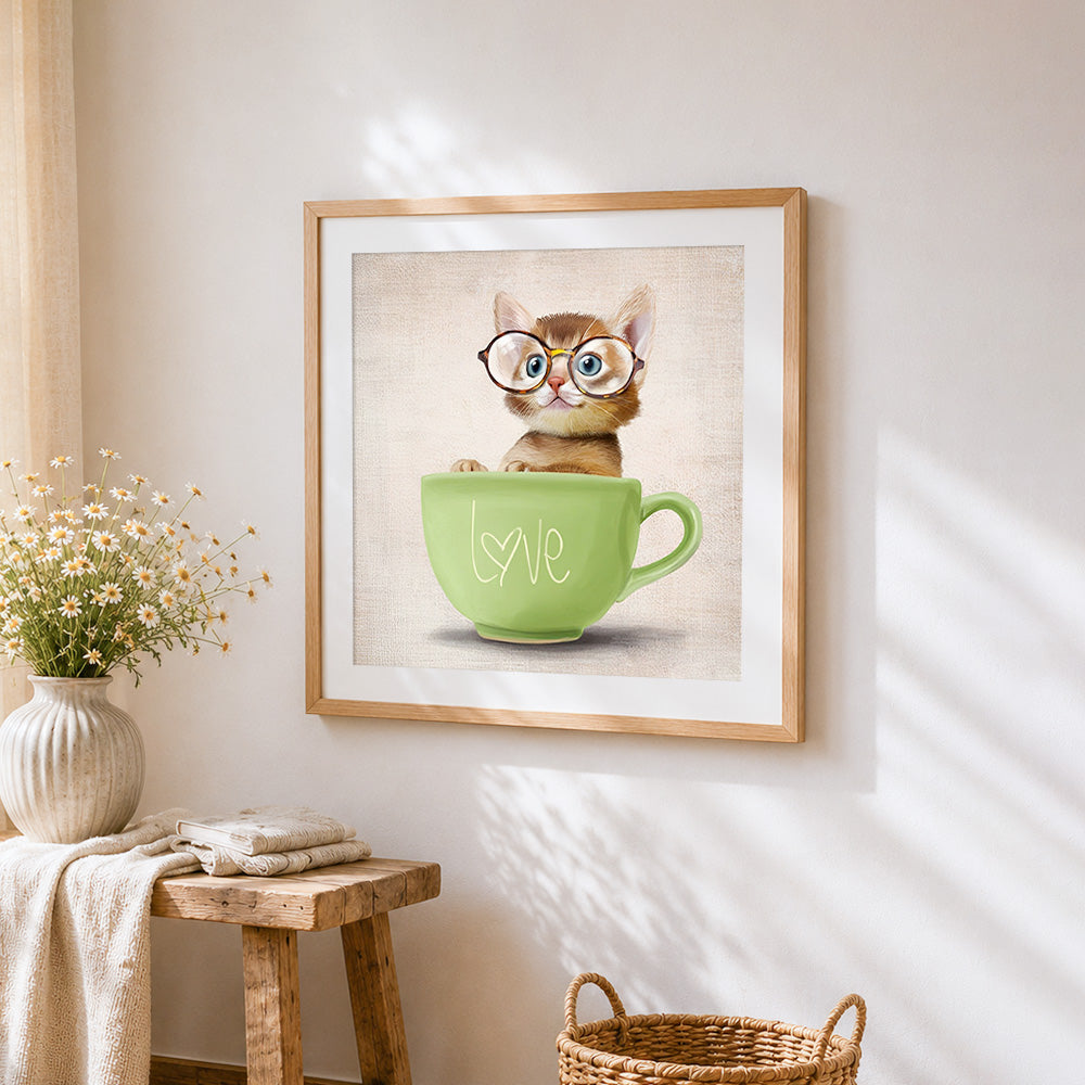 Cute kitten in a green "love" teacup cross stitch artwork displayed on wall as home decor