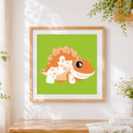 Finished cute orange spiky dinosaur cross stitch artwork displayed