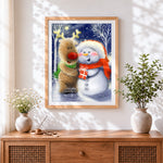 Finished cute red-nosed reindeer and snowman cross stitch artwork displayed