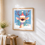 Cute reindeer in a santa hat cross stitch artwork displayed on wall as home decor