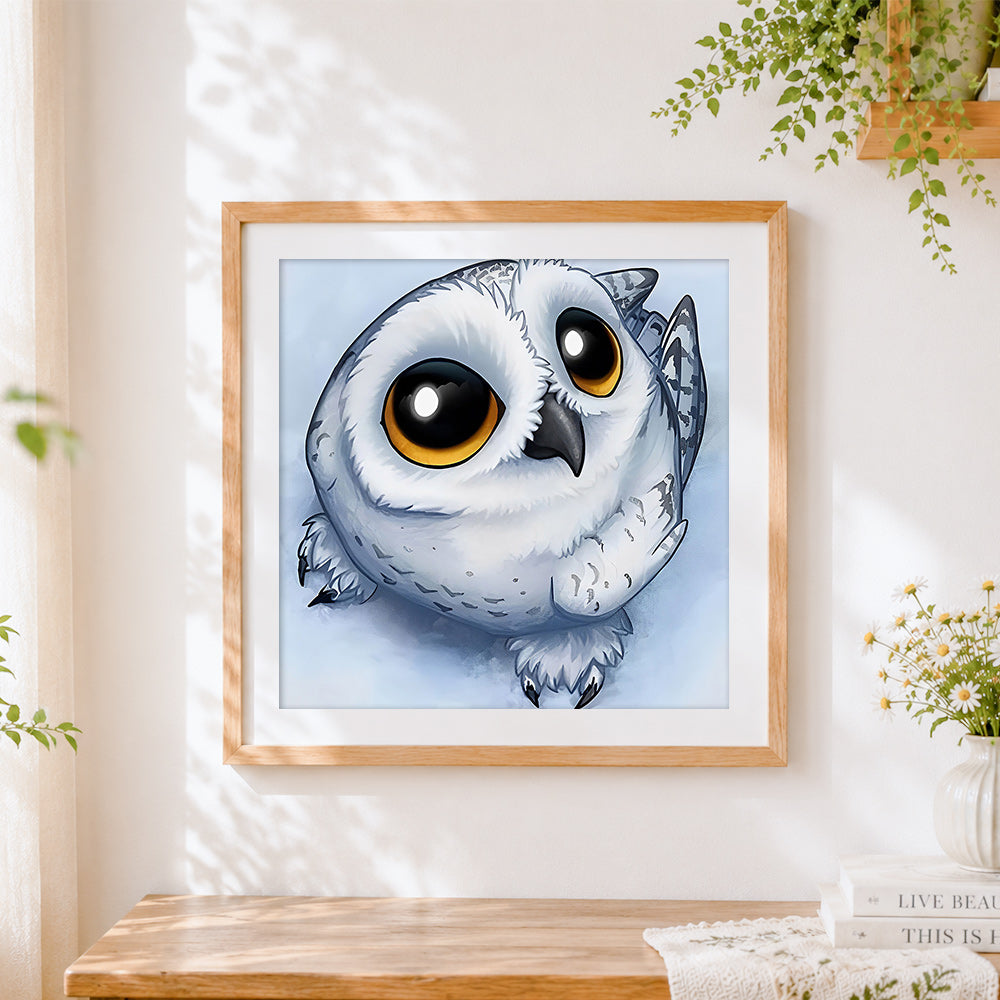 Finished cute round snowy owl cross stitch artwork displayed