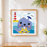 Finished cute sailor seal and lighthouse cross stitch artwork displayed