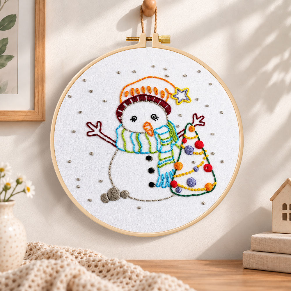 Cute snowman and tree embroidery hoop wall art displayed as warm and cosy handmade home decor