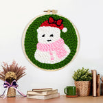 Finished cute snowman in santa hat artwork displayed on a wall