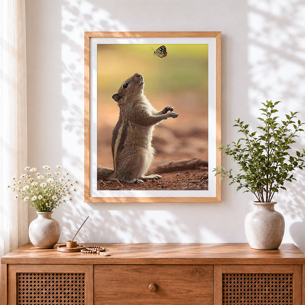 Finished cute squirrel reaching for a butterfly cross stitch artwork displayed