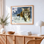 Cute tabby kitten running in snow cross stitch artwork displayed on wall as home decor