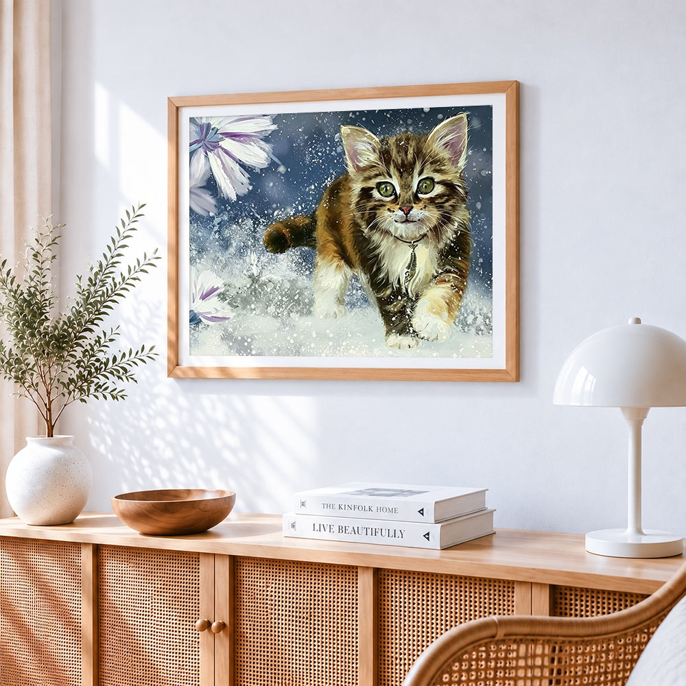 Cute tabby kitten running in snow cross stitch artwork displayed on wall as home decor