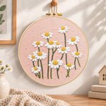 Daisies on dusty pink fabric embroidery hoop wall art displayed as warm and cosy handmade home decor