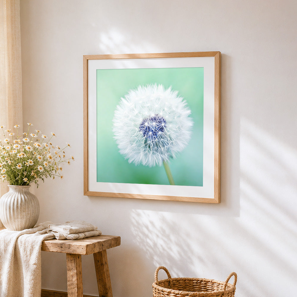 Dandelion seed on green background cross stitch artwork displayed on wall as home decor
