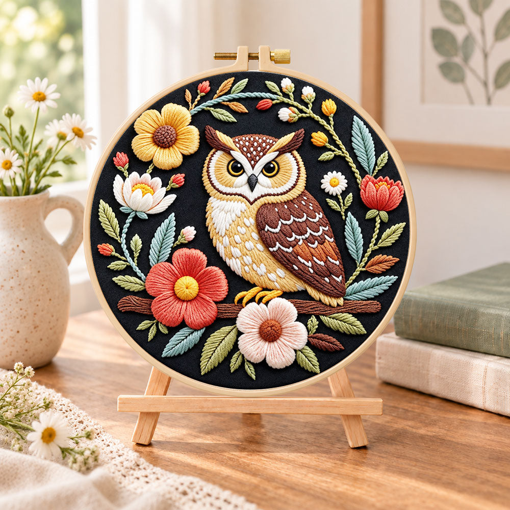 Dark floral owl embroidery kit finished hoop displayed on a wooden stand as cosy tabletop decor