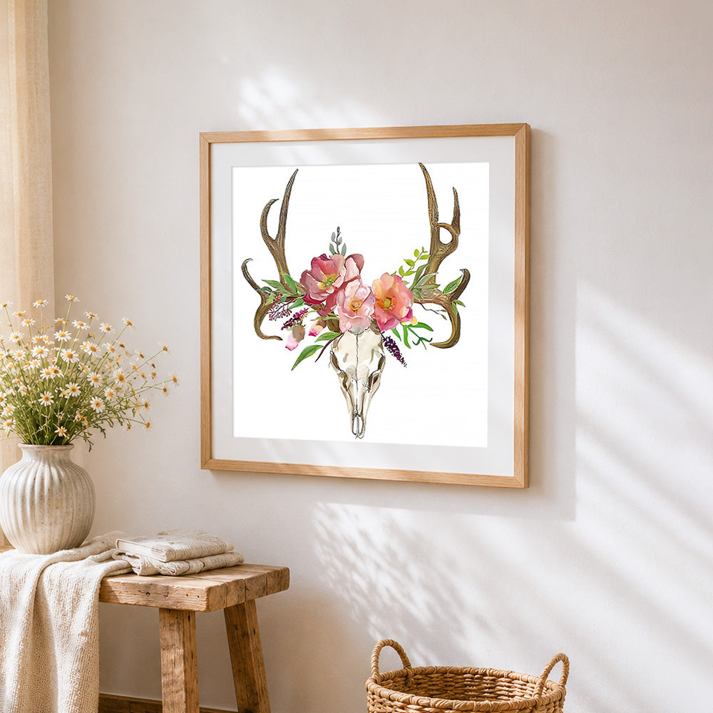 Deer skull with pink flowers cross stitch artwork displayed on wall as home decor