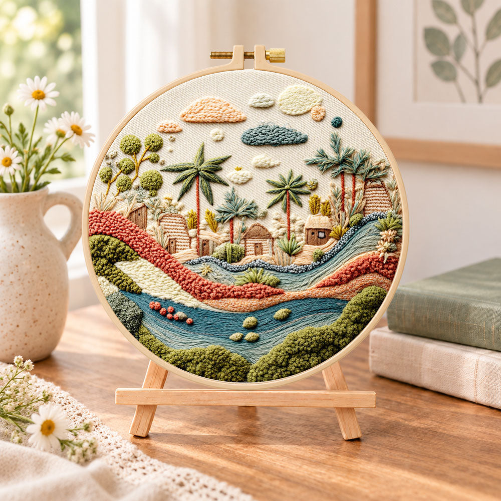 Desert stream hamlet embroidery kit finished hoop displayed on a wooden stand as cosy tabletop decor